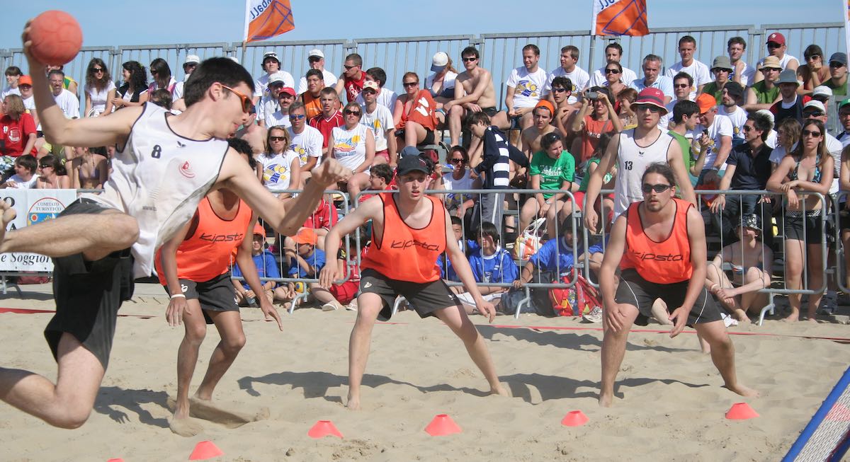 David en train de tirer, jouant sur sable avec l'équipe suisse devant un public nombreux